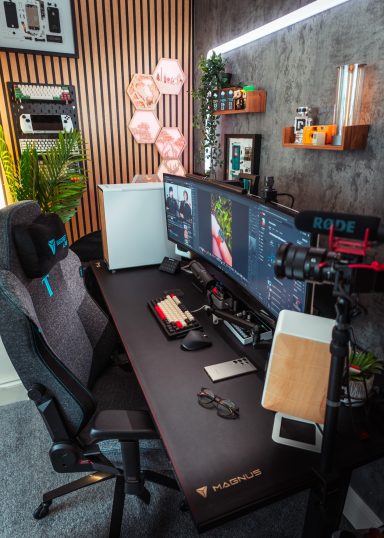 A modern gaming setup featuring dual monitors, a comfortable chair, and decorative plants.