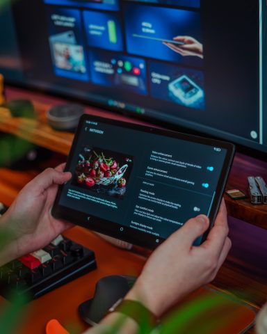 A person holding a tablet displaying a vibrant food menu.