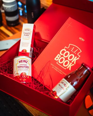 A red gift box containing a cookbook and two condiments.